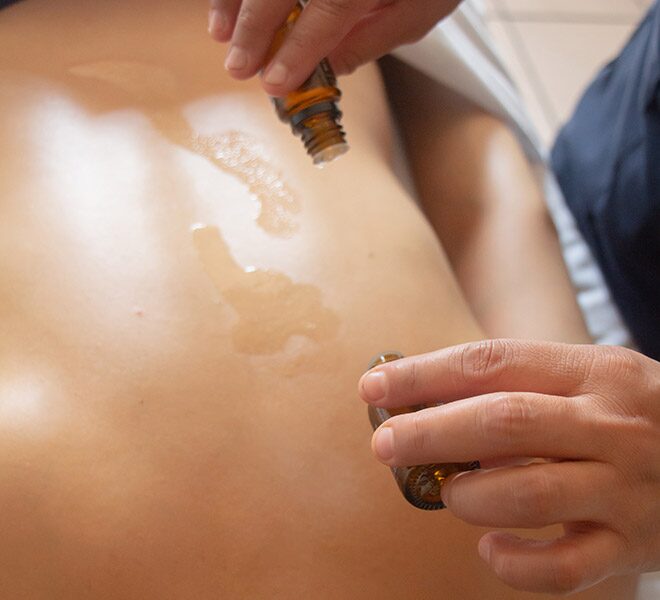 A Paxio therapist applying essential oils on a back